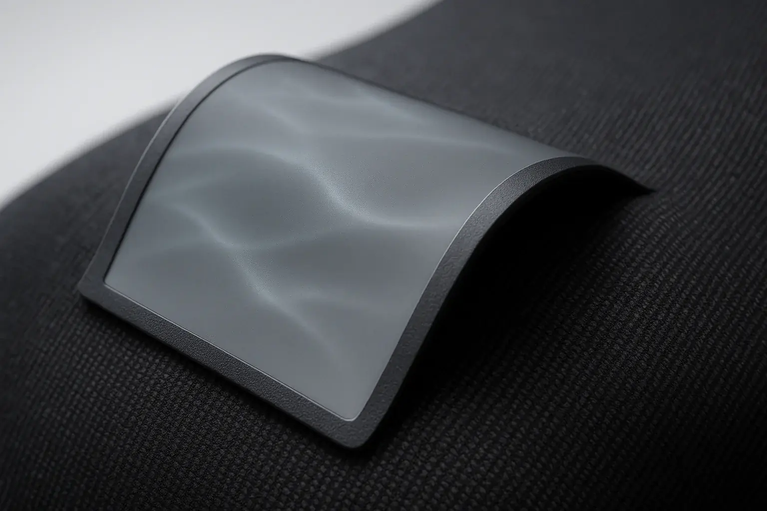Ultra-thin, flexible E-Ink display seamlessly merging with fabric, gently curved to demonstrate its adaptability for